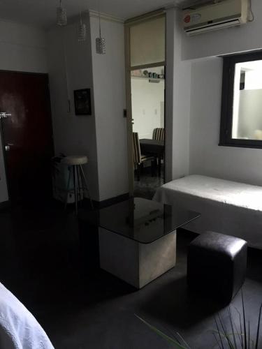Departamento excelente ubicación في لا بلاتا: غرفة بسرير ومرآة وطاولة
