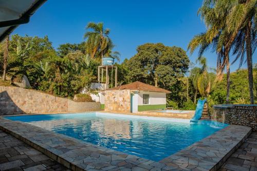 a swimming pool in a villa with palm trees at Sitio Vila Cristina - Mogi in Mogi das Cruzes