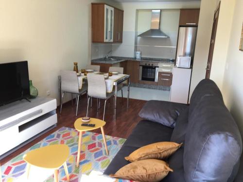 Una sala de estar con un sofá y una cocina. en Lazaro Sol, en Viveiro