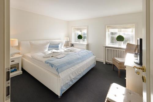 um quarto branco com uma cama e 2 janelas em Wattläufer em List