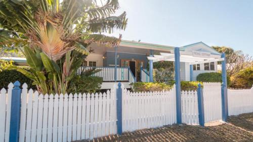 a white picket fence in front of a house at Picnic Cottage, Lovely Home Near The Beach in Picnic Bay