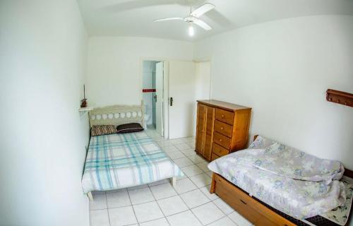 a bedroom with two twin beds and a dresser at Apartamento Wembley Tenis - Ubatuba 33 in Ubatuba