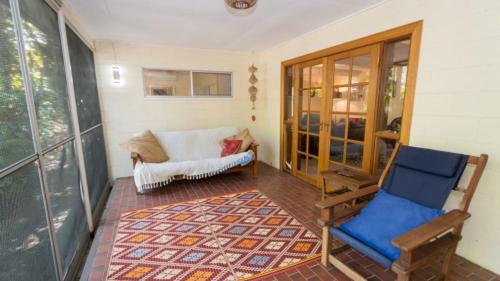 Habitación con sofá, silla y alfombra. en Moana Cottage, Stroll To Horseshoe Bay Beachfront, en Horseshoe Bay