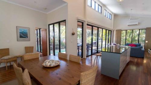 a dining room and living room with a wooden table at Barefoot Beach House in Horseshoe Bay