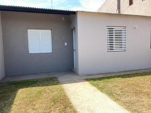 una casa gris con dos ventanas y una puerta en salta 1019 Apart Firmat 5 en Firmat