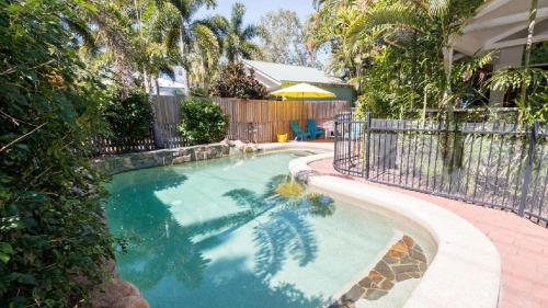 een zwembad in een tuin met een hek bij Magnetic Dreams Unit 1 in Arcadia