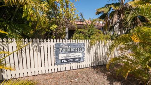 a white picket fence with a sign on it at The Ponderosa Holiday House in Horseshoe Bay
