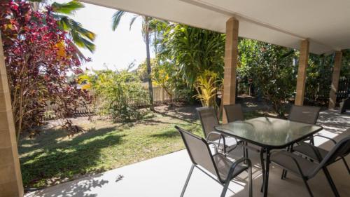 a patio with a table and chairs and a garden at The Ponderosa Holiday House in Horseshoe Bay