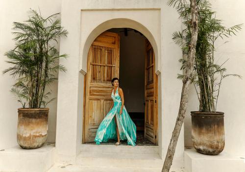 a woman in a blue dress standing in front of a door at Yum Kaax Boutique Villa in Tulum