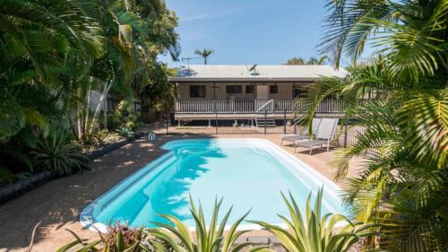 a swimming pool in front of a house at Sunbird On Corica in Horseshoe Bay