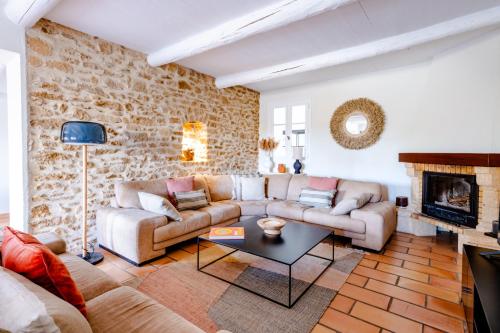 ein Wohnzimmer mit einem Sofa und einem Kamin in der Unterkunft Mas de la Fontaine in Sarrians