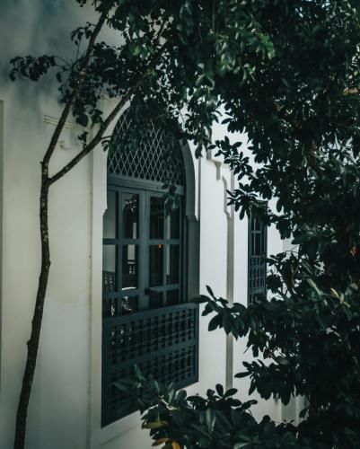 an open window on a white building with trees at Yum Kaax Boutique Villa in Tulum