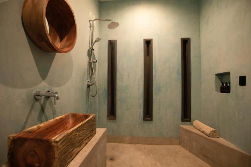 a bathroom with a shower with a wooden tub at Yum Kaax Boutique Villa in Tulum