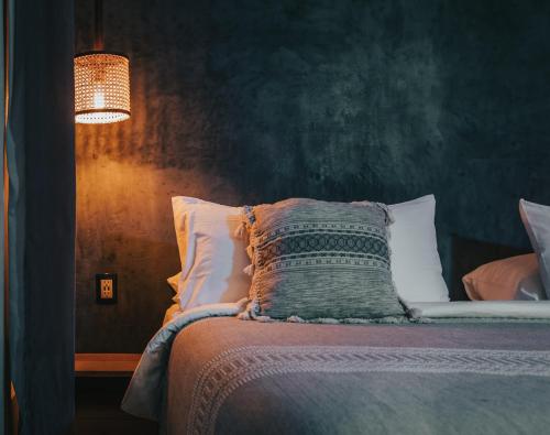 a bedroom with a bed with a pillow and a lamp at Yum Kaax Boutique Villa in Tulum