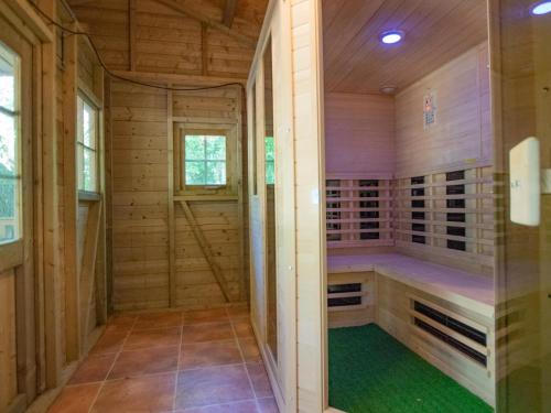 a sauna with wooden walls and a green floor at Villa Maashorst in Uden