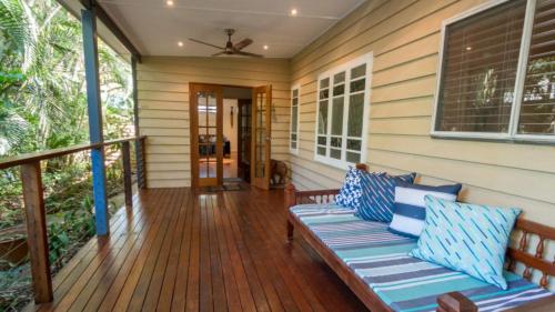 une terrasse couverte avec un banc sur une maison dans l'établissement Tamarinds Beach House, à Arcadia