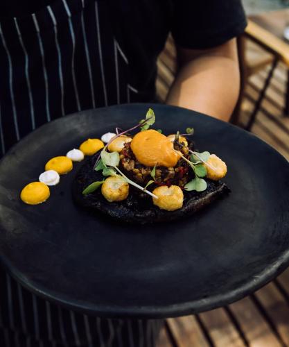 a plate of food on a black plate at Yum Kaax Boutique Villa in Tulum