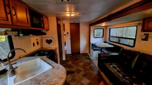 an rv kitchen with a sink and a couch at Llaimadomo Melipeuco in Melipeuco