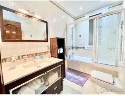 baño con lavabo y aseo y ventana en Santuchu Apartamento Elegante con wifi, en Bilbao