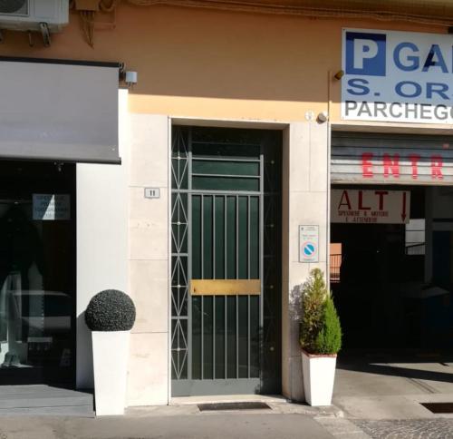 einen Laden mit grüner Tür und zwei Pflanzen in der Unterkunft Casamia in Bologna
