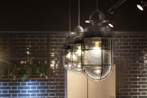 a chandelier with lights hanging from a brick wall at ALPHABED INN 小樽駅前 in Otaru