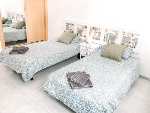 two beds in a room with a mirror at CASA MIRAMAR in Corralejo