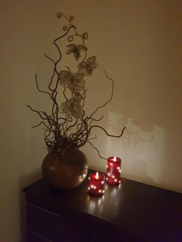 a vase sitting on a table with two candles at Beautiful Double En-suite Room, separate entrance, Ilford, Central line Gants Hill, free parking in Ilford