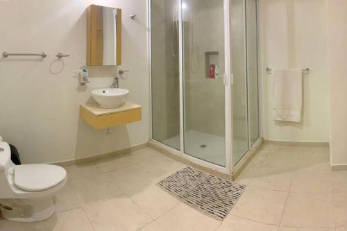 a bathroom with a shower and a toilet and a sink at Moderno condo de 1 rec con alberca 5 mins a playa 103b in Cabo San Lucas