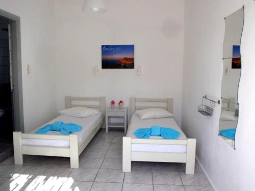 a bedroom with two beds and a mirror at Pavlosx2 in Chora Folegandros