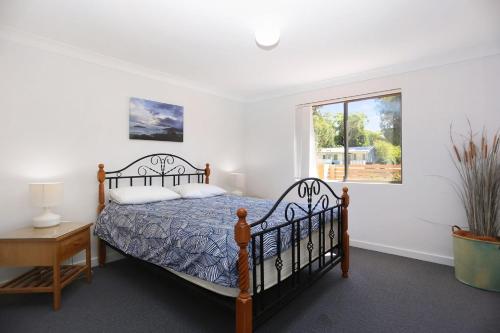 ein Schlafzimmer mit einem Bett und einem Fenster in der Unterkunft Resort Style Holiday in Hawks Nest