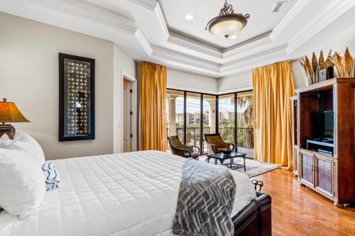 a bedroom with a king sized bed and a television at Villa by the Sea in Destin