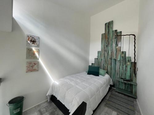 ein Schlafzimmer mit einem weißen Bett an einer weißen Wand in der Unterkunft Okeyloft Coyhaique 3 in Coihaique