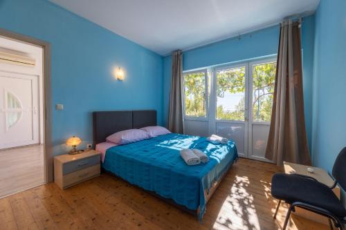 a blue bedroom with a bed and a chair at Apartment Asja in Ivan Dolac