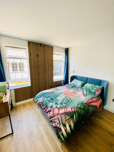 a bedroom with a bed with a colorful bedspread at New studio flat overlooking city centre in Kingston upon Thames