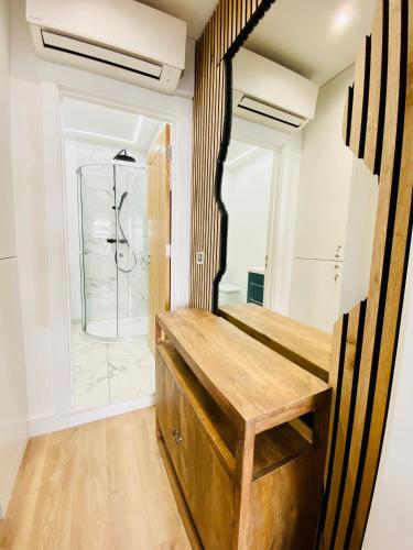 a bathroom with a shower and a wooden bench at New studio flat overlooking city centre in Kingston upon Thames