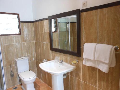 uma casa de banho com um lavatório, um WC e um espelho. em SAARA HOTEL em Mahajanga