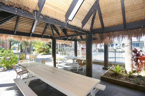 a picnic table under a straw umbrella on a patio at Providence Apartment 5 in Hawks Nest