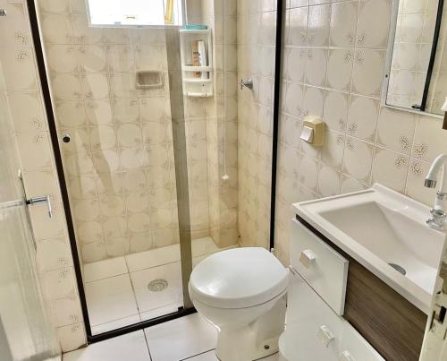 y baño con ducha, aseo y lavamanos. en Apto espaçoso uma quadra do mar com garagem, en Balneário Camboriú