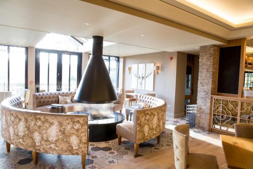 a living room with a fireplace and a table and chairs at Bovey Castle in Moretonhampstead