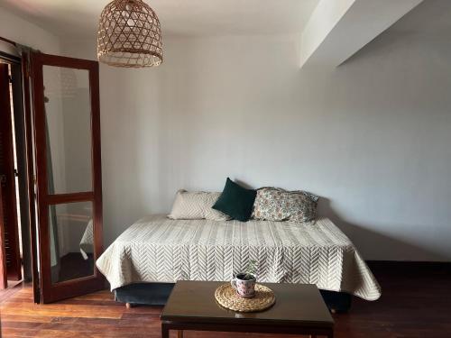 een slaapkamer met een bed met een tafel en een lamp bij LAJUACA II in San Salvador de Jujuy