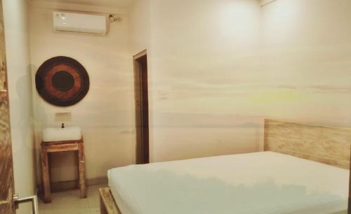 1 dormitorio con 1 cama y mesa auxiliar en A-Manta Homestay, en Labuan Bajo