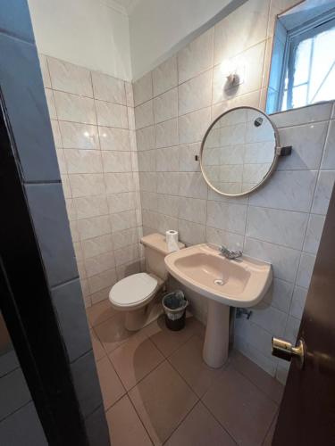 a bathroom with a sink and a toilet and a mirror at HOSPEDAJE DA VINCI PARA TURISTAS y PERSONAL LABORAL in Calama