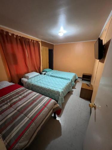 1 dormitorio con 2 camas y TV. en HOSPEDAJE DA VINCI PARA TURISTAS y PERSONAL LABORAL, en Calama