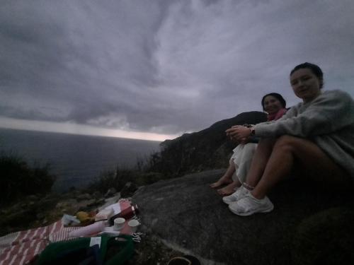 dos personas sentadas en una roca con vistas al océano en GIA THÀNH HOMESTAY en Hoi An