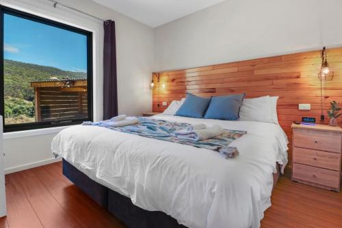 1 dormitorio con 1 cama grande y ventana grande en Alpine Twin Heights, en Mansfield