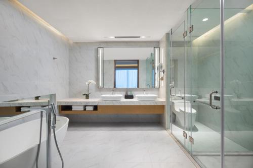 a bathroom with two sinks and a shower and a mirror at Metropark Hotel Hongqiao Shanghai in Shanghai