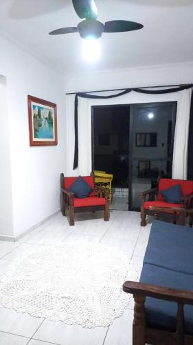 a living room with two couches and a ceiling fan at apartamento pé na areia Mongaguá in Itanhaém