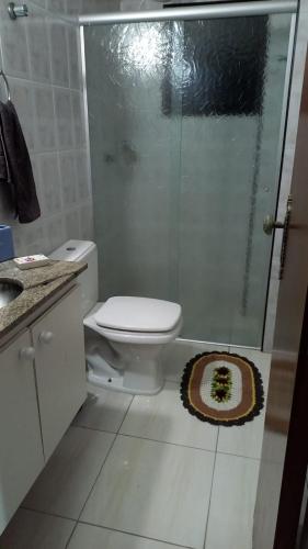 a bathroom with a toilet and a glass shower at apartamento pé na areia Mongaguá in Itanhaém