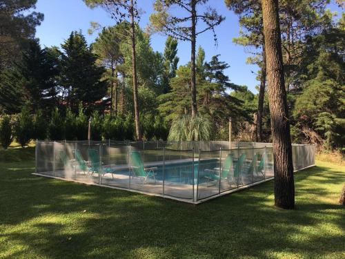 una piscina con sillas en un patio en Casa Carilo en Cariló