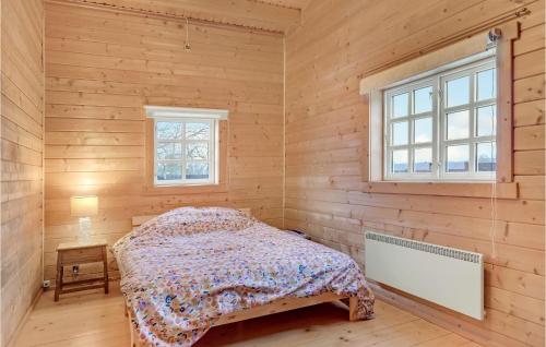 赫爾辛厄的住宿－Cozy Home In Helsinge With Kitchen，卧室配有一张床铺,位于带木墙的房间内